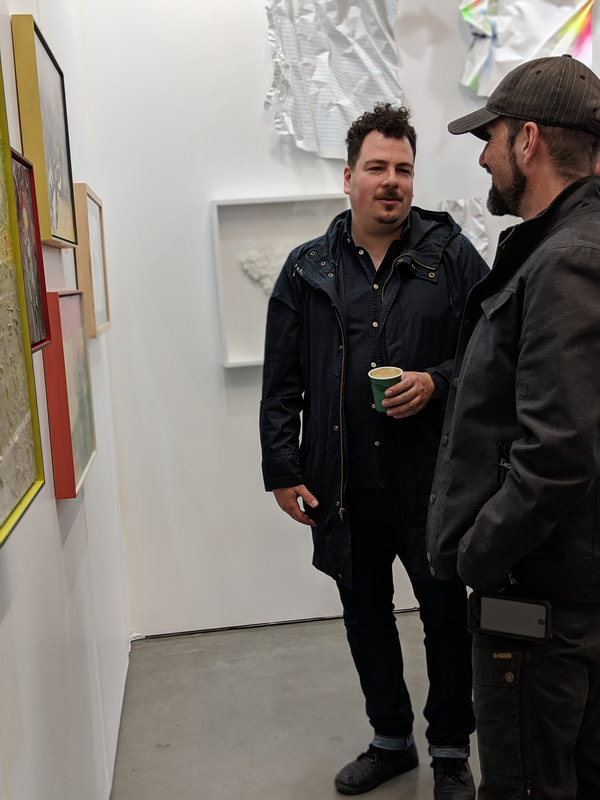 Guillaume Klootier en discussion avec un amateur d'art lors de la Foire d'art contemporain Papier, avril 2019